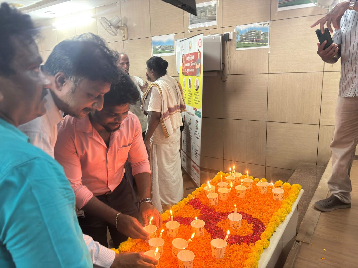Participants lighting candles on a bed of marigolds